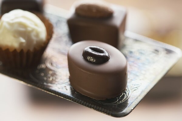 Beaux chocolats sur un plateau décoré de café