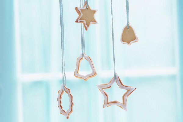 Biscotti di Capodanno a forma di stelle e campane appesi a nastri