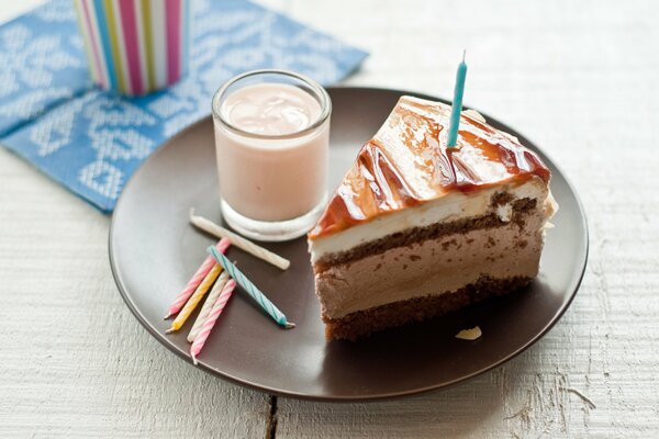 Torta con candele e latte su un piatto