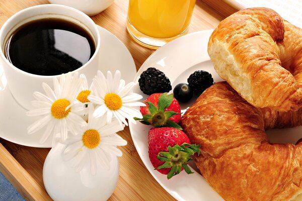 Frühstück auf einem Tablett, Kaffee und Croissants