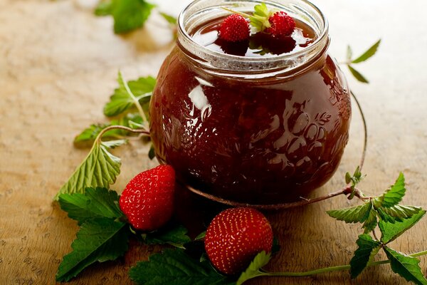 Jam jar surrounded by leaves and berries