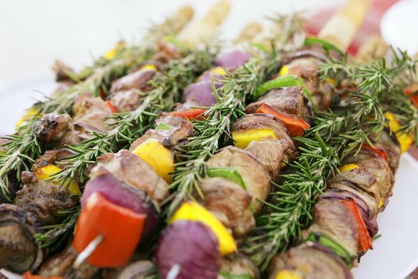 Leckeres Fleisch mit Gemüse auf Spießen und Zweigen von Grüns