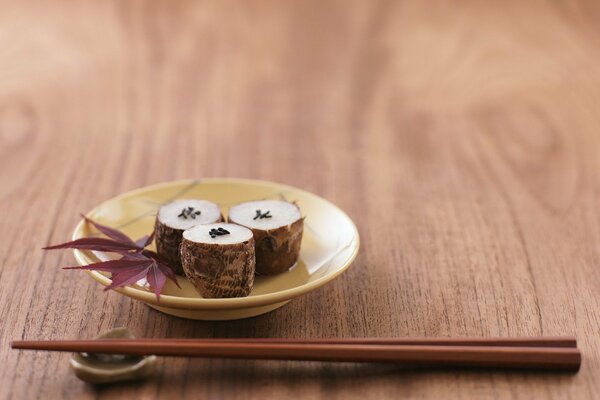 Sushi en un plato y con palillos en la mesa