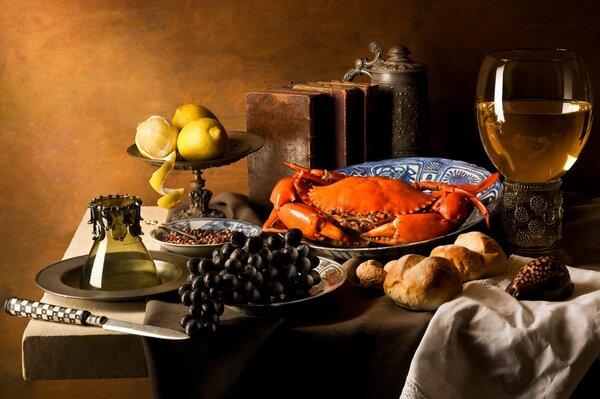 Crab in a dish on the table with grapes, lemons and a drink