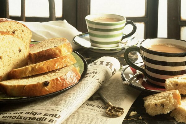 Frühstück mit Kaffee, Brot und Zeitung