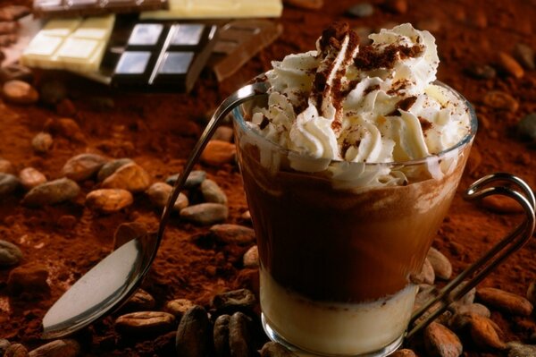 Una taza de chocolate caliente con crema está en la mesa