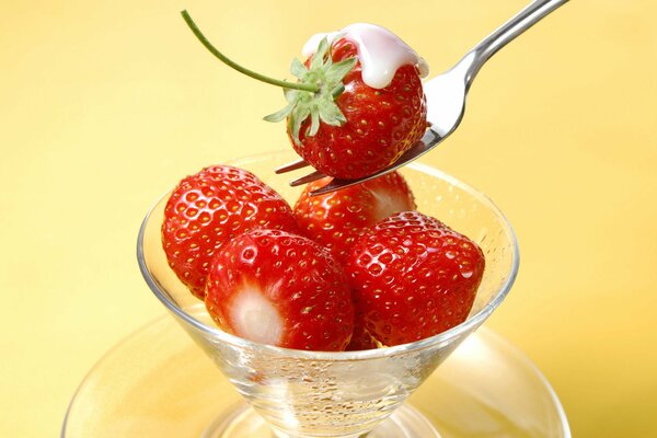 Strawberries in cream are served in a glass