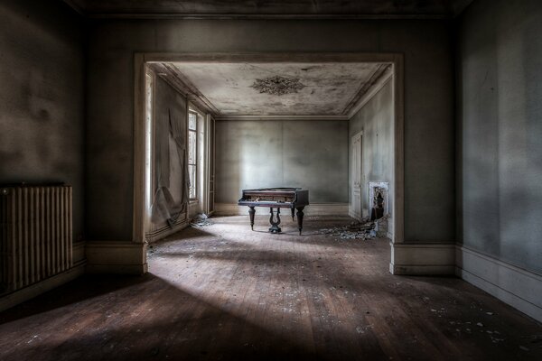 Chambre sombre avec piano et fenêtre