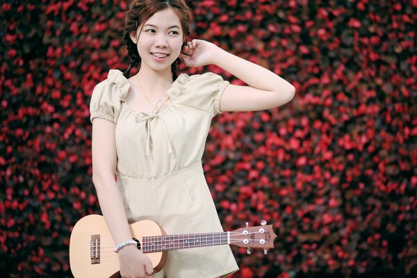 Una chica sonriente con una guitarra en la mano