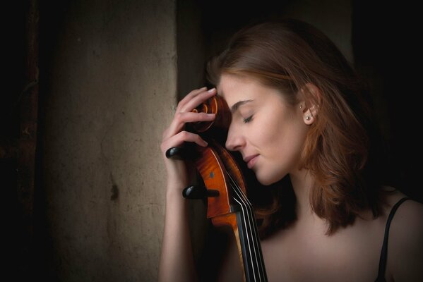 Giovane ragazza appoggiata al violoncello