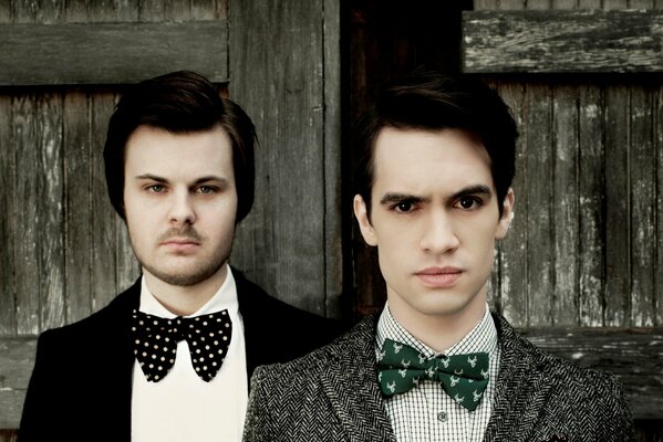 Two young men on the background of an old barn