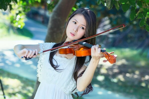 A girl playing the violin in the garden