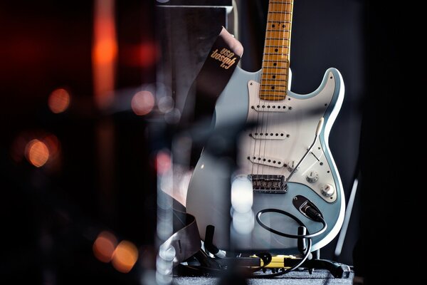 Blaue Gitarre auf dem Hintergrund der verschwommenen Lichter