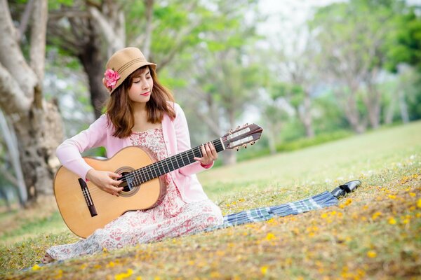 Mädchen mit Hut spielt Gitarre