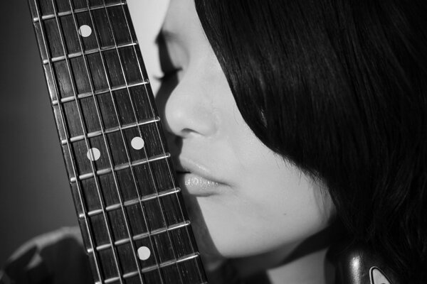 Foto en blanco y negro con una chica y una guitarra