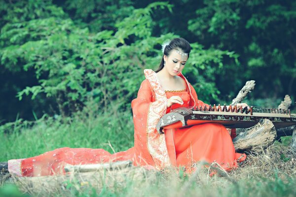 Ragazza che suona uno strumento musicale Asiatico