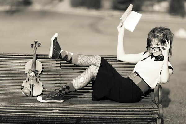 Fille se trouve sur un banc avec un violon