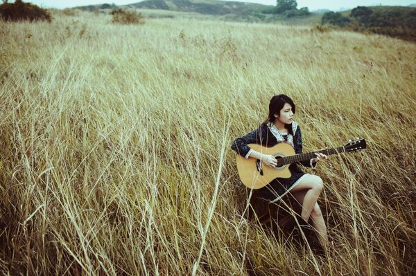 Fille avec une guitare dans le domaine