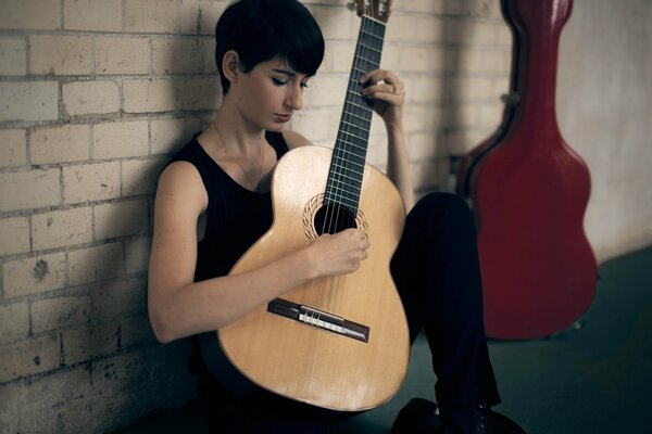 A girl plays music on a guitar