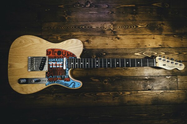 Guitarra reclinada en una mesa de madera