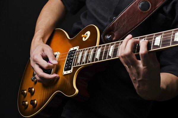 Primo piano di chitarra elettrica e mani