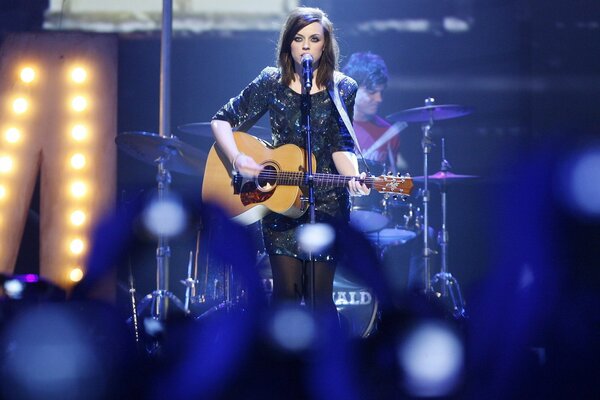 Amy McDonald plays guitar and sings at a concert