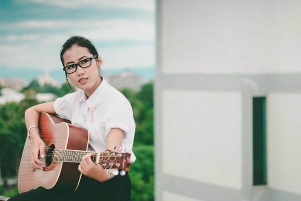 Fille avec des lunettes avec une guitare