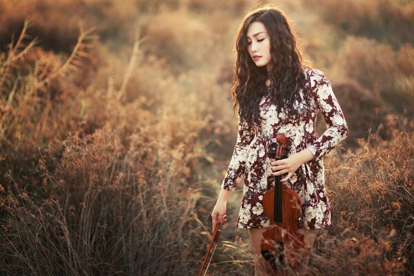 Ragazza con violino in mano nel campo