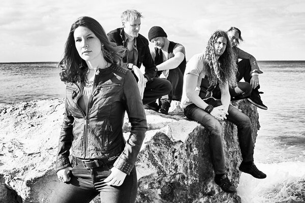 Gruppo di Delain sulla riva seduti sulle rocce