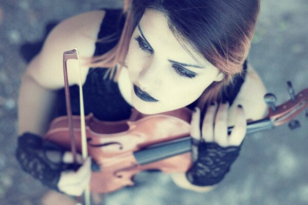 A violinist girl with a violin and a bow