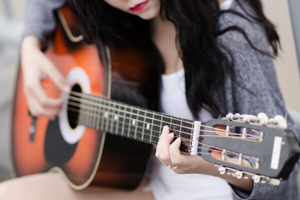 The girl plays the guitar