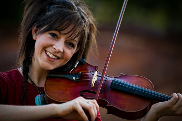 The girl plays the violin and smiles