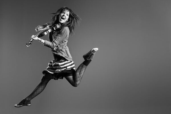 Lindsay Stirling with a violin in a jump