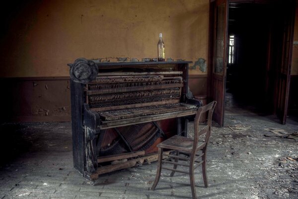 A bottle on the piano and an old chair