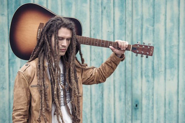 Jeune homme avec une guitare sur l épaule