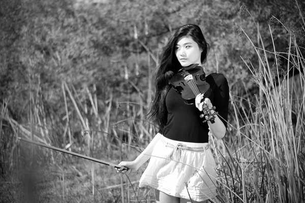 Fille avec violon sur fond noir et blanc