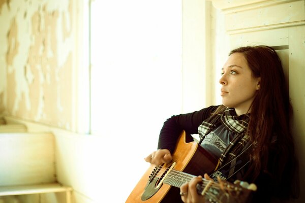 La cantante Carly Gibson si siede con una chitarra