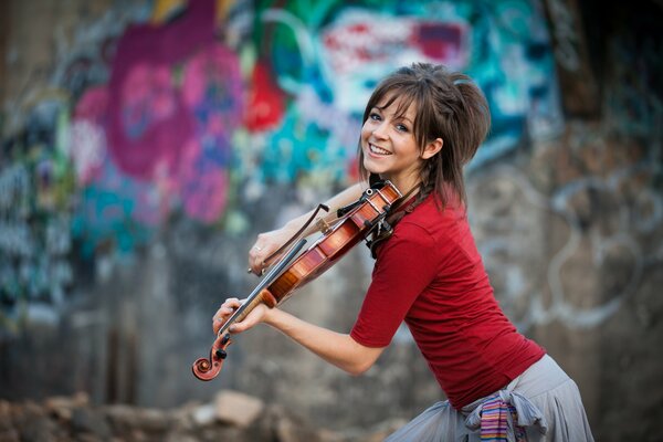 A smiling girl plays the violin