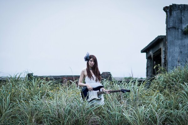 Fille avec une guitare dans l herbe haute