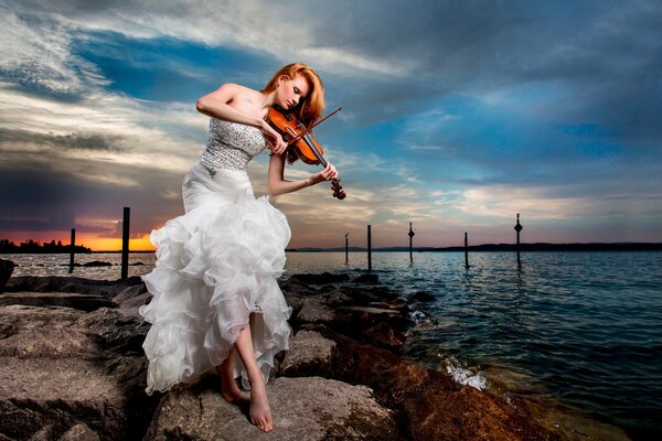 Ragazza in abito bianco suona il violino