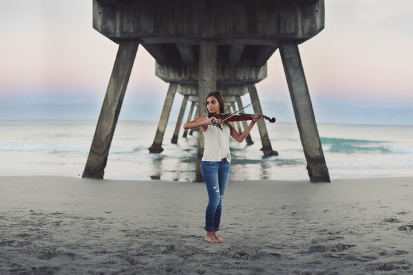 A girl on the seashore plays the violin