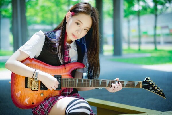 Oriental chica con la guitarra en la mano