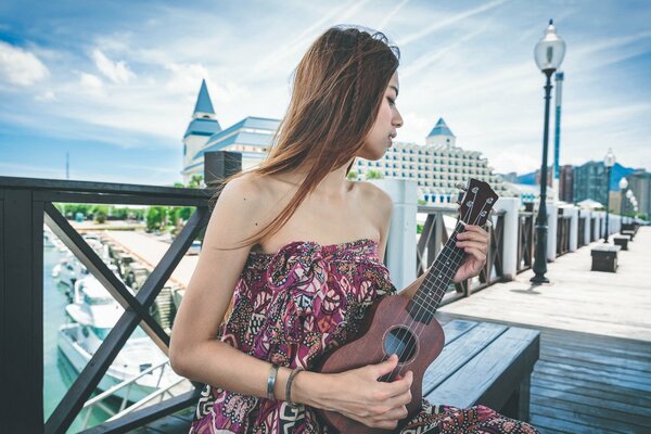 Guitarra en manos de una hermosa asiática