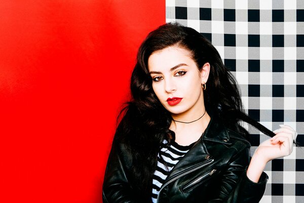 Brytyjska piosenkarka Charli XCX na czerwonym i kraciastym tle z czerwonymi ustami