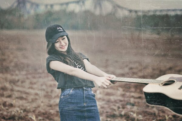 Asian girl with guitar in the field