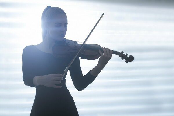 A girl playing the violin in the light