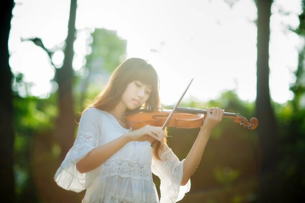 Asian girl plays music on the violin