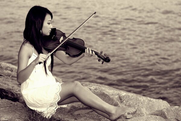 Asiático tocando el violín en el fondo de la superficie del agua