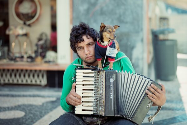 Musicien de rue avec un chien sur l épaule