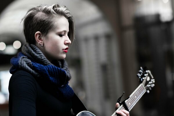 A girl with a guitar with a creative hairstyle